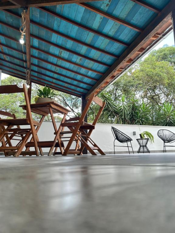 a group of chairs and tables under a roof at casa de mineiro in Tiradentes