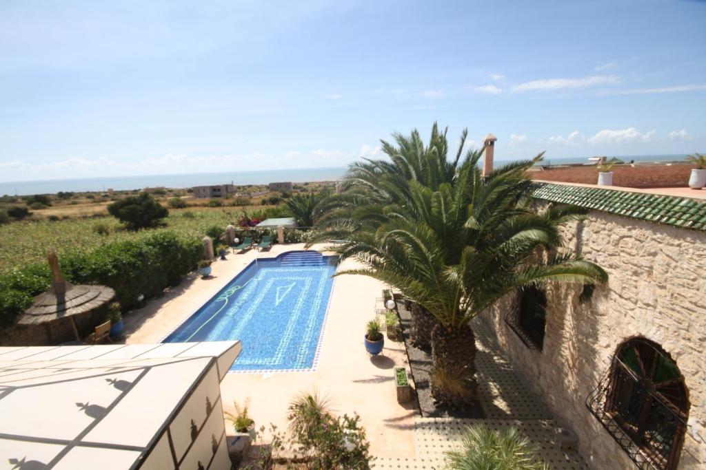 a villa with a swimming pool and palm trees at Suite majorelle in Moulay Douraïne