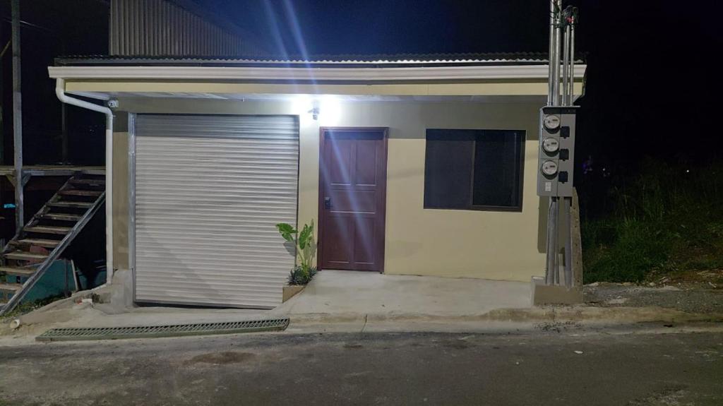 a small house with a garage with a purple door at Apartment Torres in Manuel Antonio
