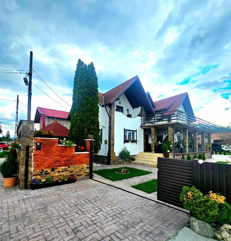 a house with a fence in front of it at Mera Holiday Inn in Albeştii Pămînteni