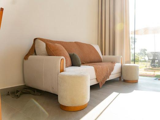 a white couch in a living room with a window at Loft Alegria in Avaré
