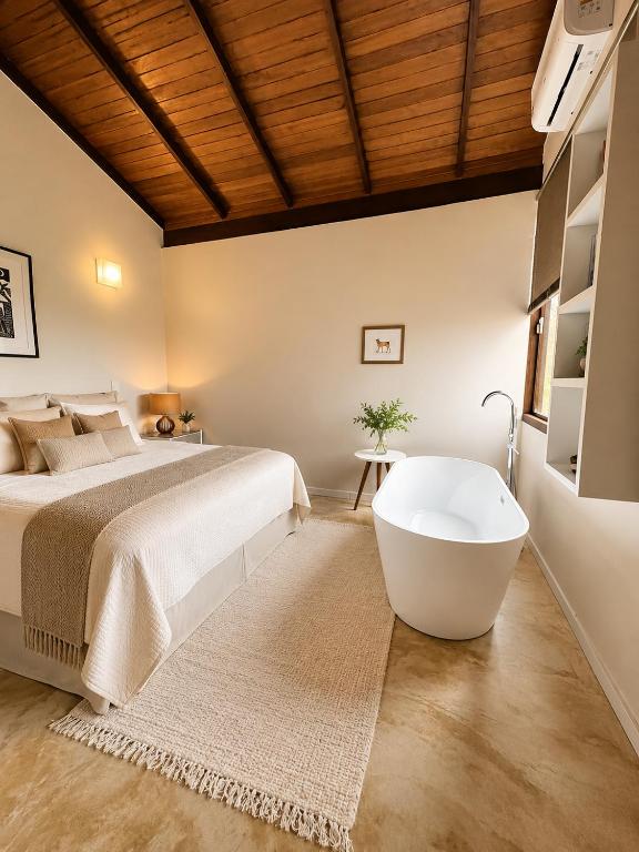 a bedroom with a large bed and a bath tub at Pariká Pousada in Alto Paraíso de Goiás