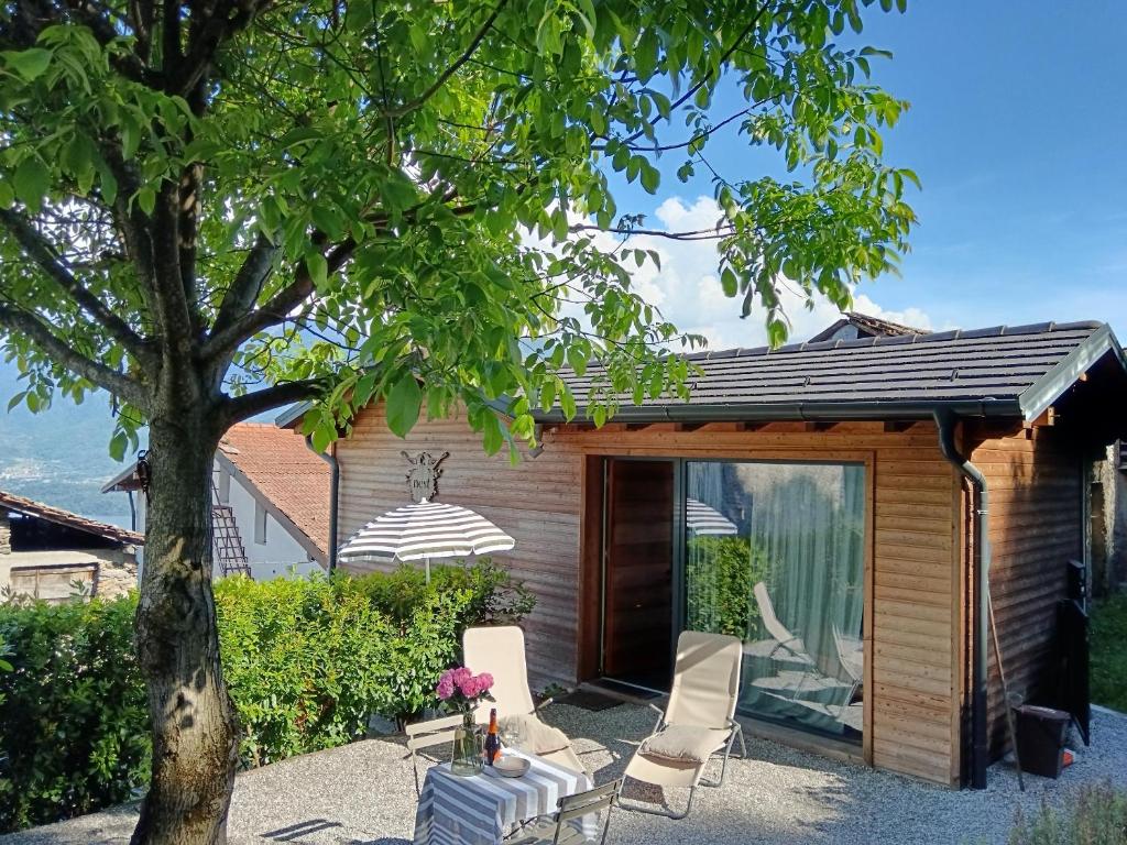 a house with a patio and a tree at Chalet Nest in Gravedona