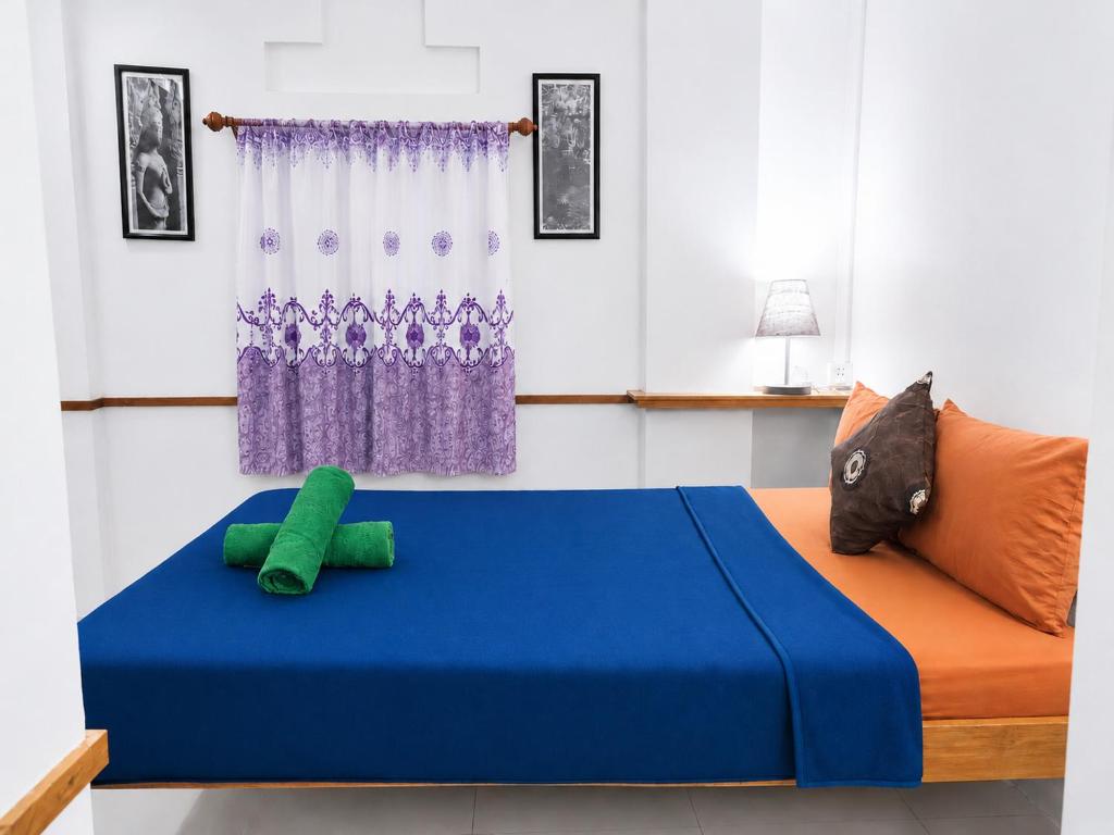 a bedroom with a bed with a blue mattress at Soben Cafe Guesthouse & Restaurant in Siem Reap