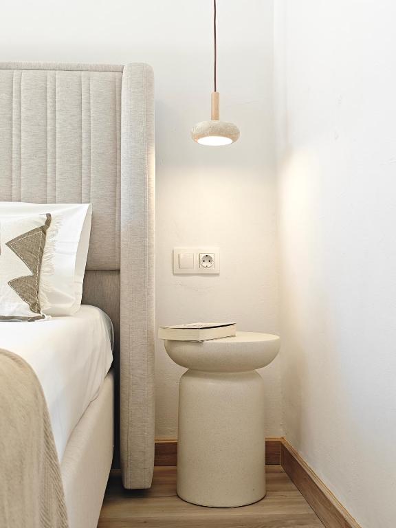 a bedroom with a bed and a nightstand next to a bed at Maison Jolie in Vlachopoulátika