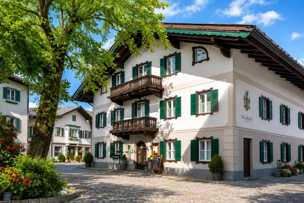 a building with green shutters and a tree at Villa Egger in Lofer