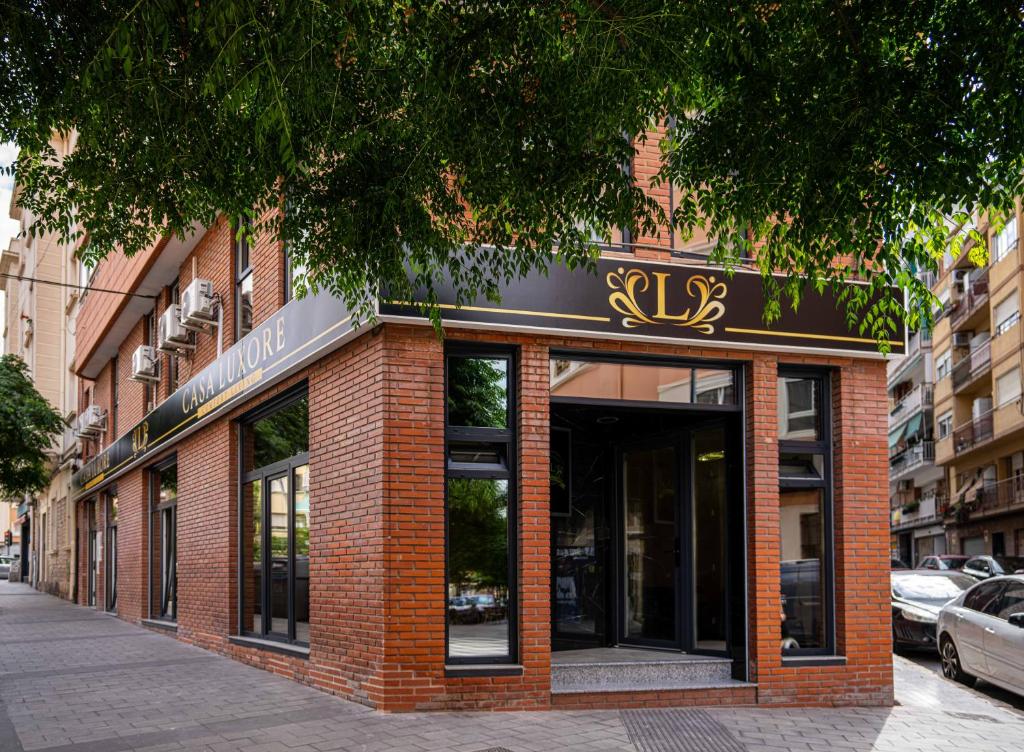 a red brick building with a sign on it at Casa Luxore in Alicante