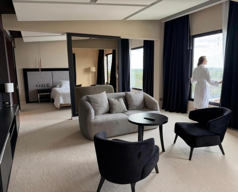 a woman standing in a living room with a couch at Azahar Hotel & Spa in San Pedro