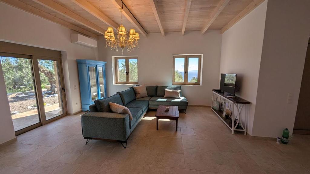 a living room with a couch and a television at Achilles Cottage in Kardamyli