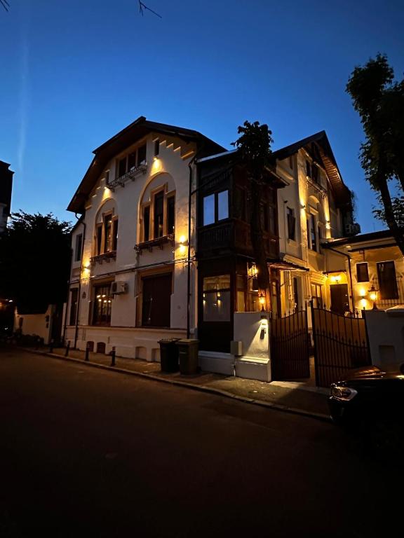 a large white house with lights on a street at Cismigiu Apartments in Bucharest