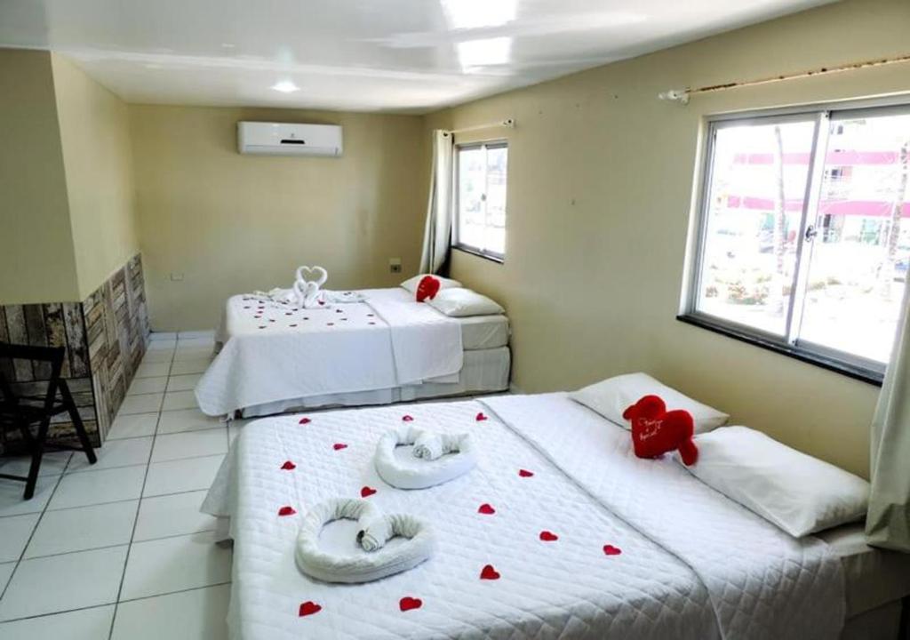 two beds in a room with red hearts on them at Pousada vila bela in Porto De Galinhas