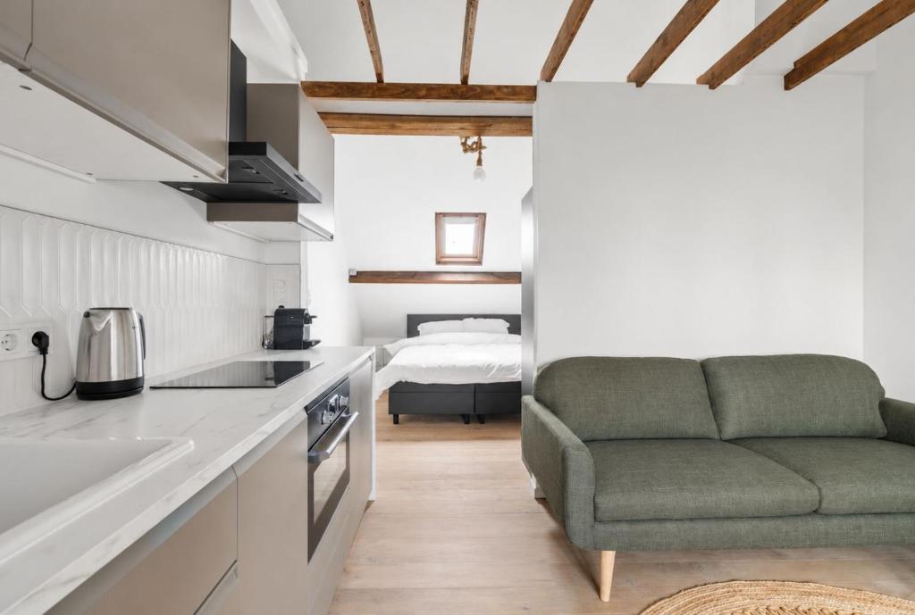 a kitchen with a couch and a bed in a room at Oyster Loft Ostend in Ostend