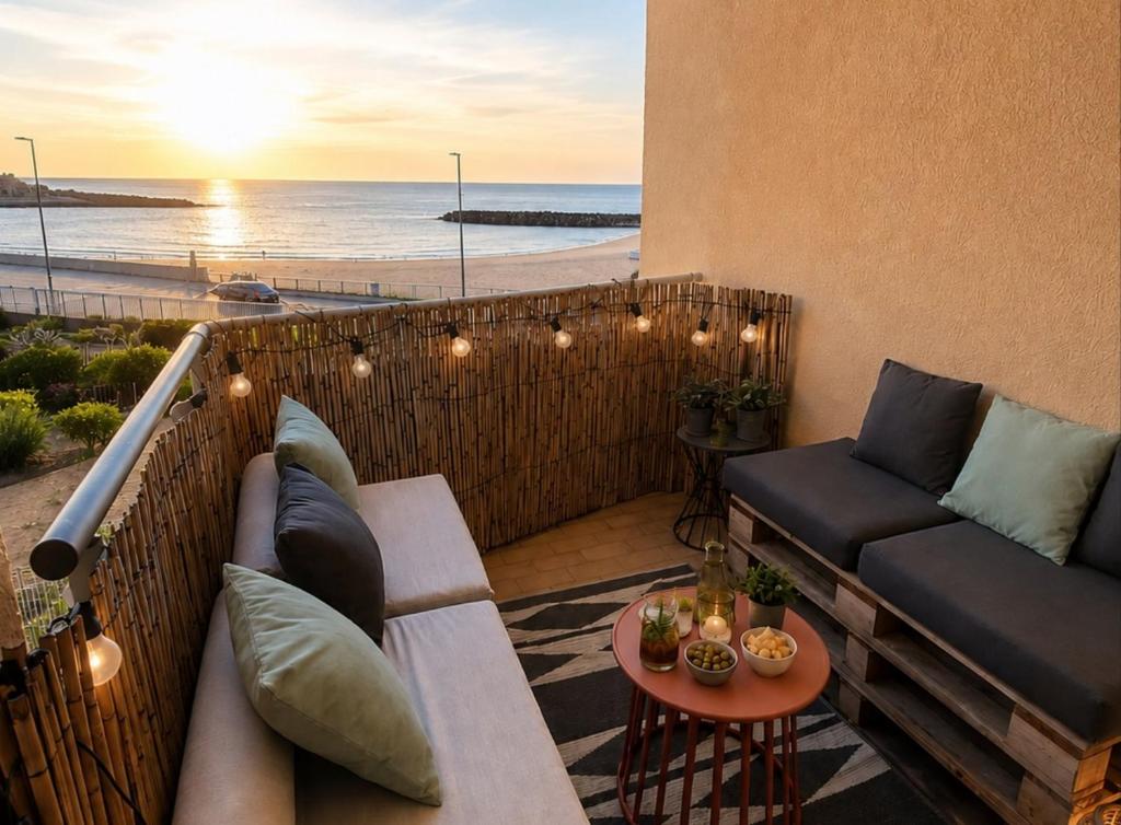 a balcony with a couch and a view of the beach at Chez Juju - petit cocon face à la mer avec parking in Sète