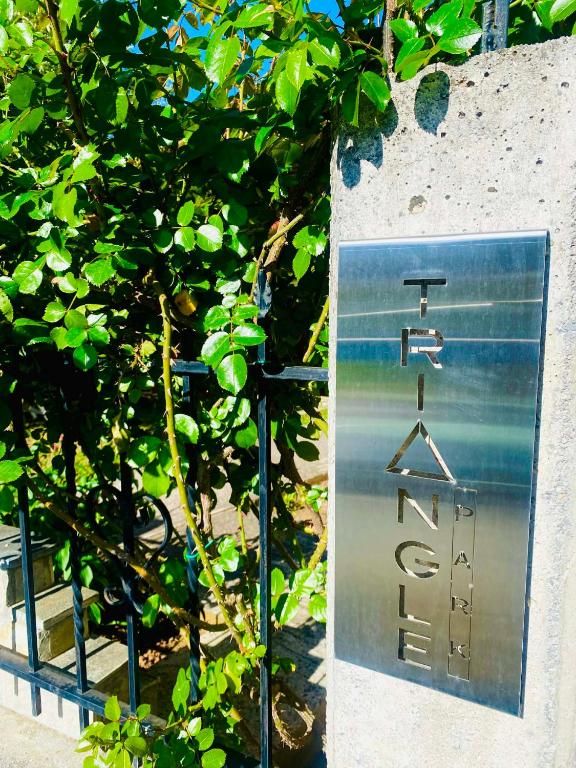 a sign with a hanger in front of a tree at Triangle Park Apartments A2 in Kozani
