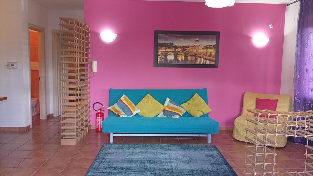 ein Wohnzimmer mit einem blauen Sofa und einer rosa Wand in der Unterkunft Helly House in Isernia