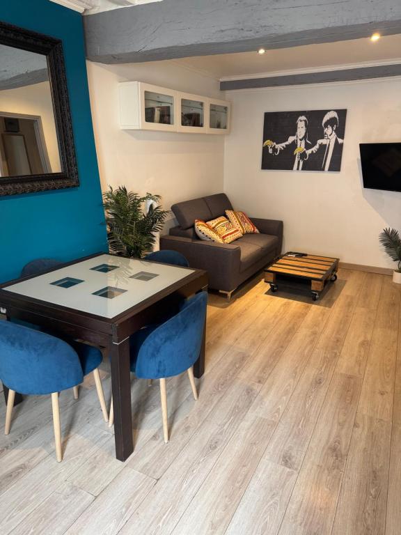 a living room with a table and a couch at Glycine in Orléans