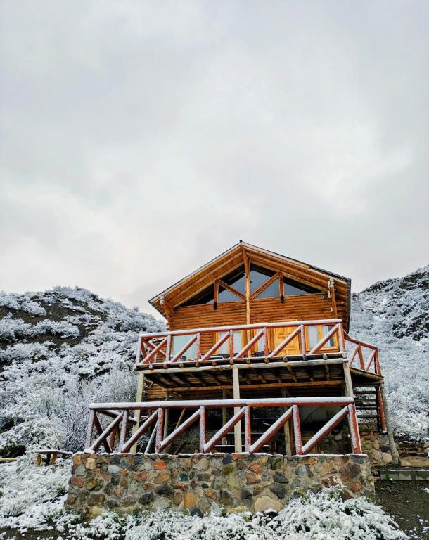 a wooden cabin in the snow on a mountain at Cabaña Rincón del Sol in Potrerillos