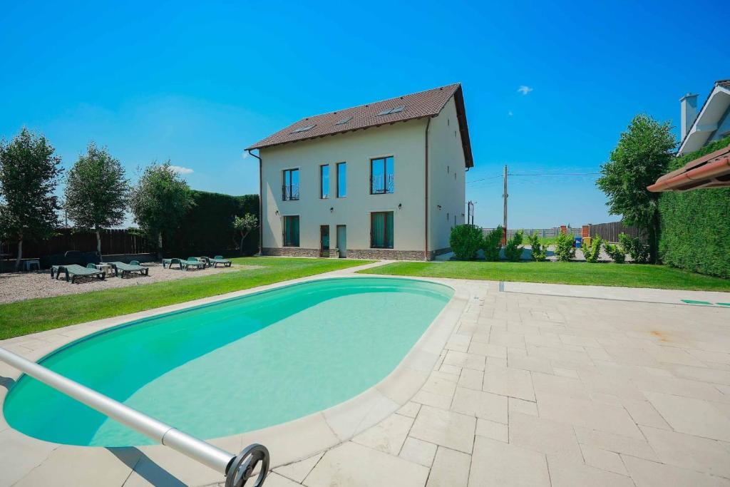a house and a swimming pool in front of a house at Sunrise Villa in Baile Felix