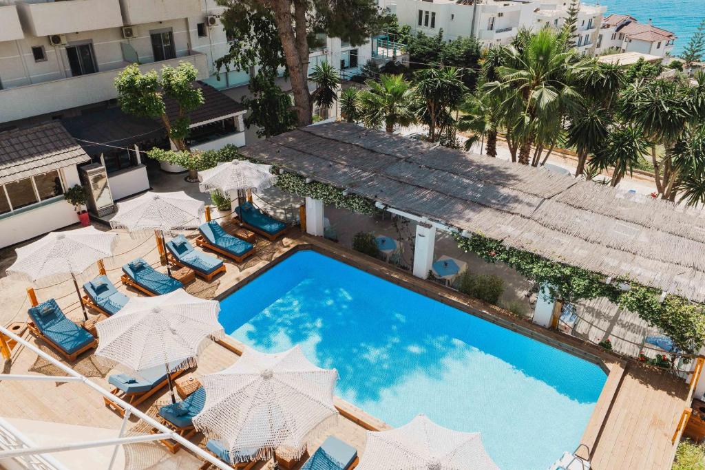 an overhead view of a swimming pool with chairs and umbrellas at Saranda Hotel in Sarandë