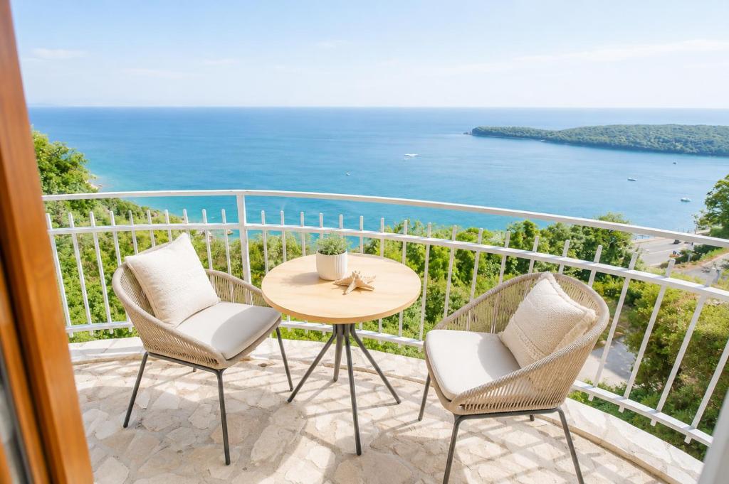 a balcony with a table and chairs and the ocean at SunSeoce Apartments in Budva