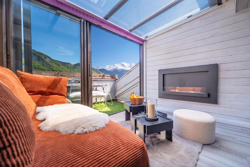 ein Wohnzimmer mit Bett und Kamin in der Unterkunft Nid face au MontBlanc - 55m2 de charme in Sallanches