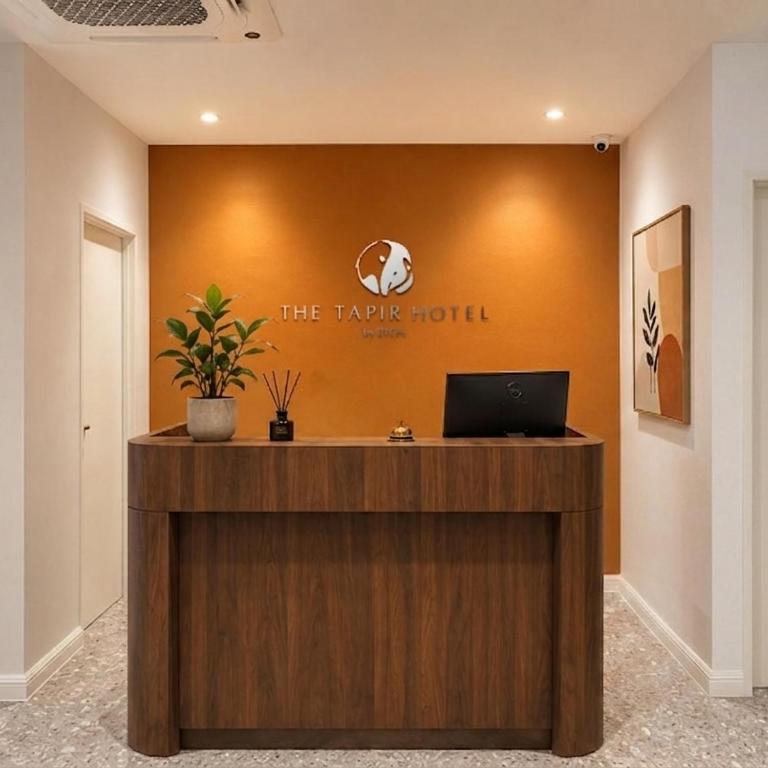 a reception desk with a laptop on top of it at The Tapir Puchong by BYON Premium Suites & Hotels in Puchong