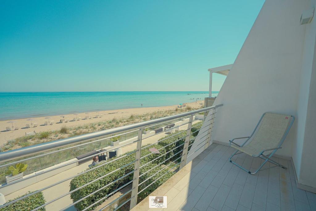ein Balkon mit einem Stuhl und der Strand in der Unterkunft Dimore di Mare in Termoli