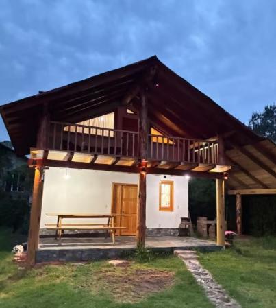 a small house with a deck and a bench at Cabañas El Borrego in Mazamitla