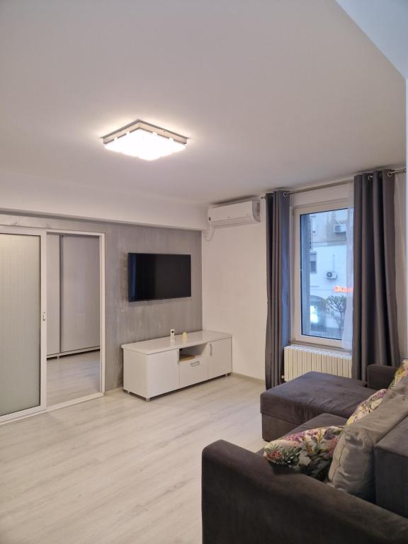 a living room with a couch and a flat screen tv at Iris ultracentral apartment in Mangalia