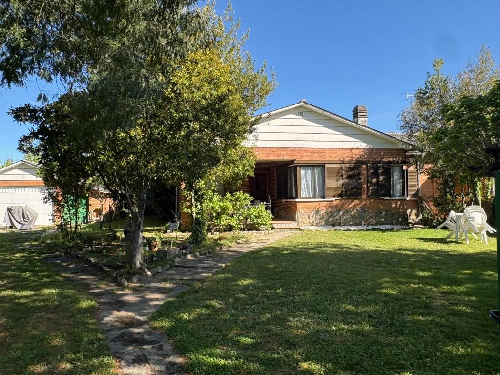 a house with a tree in the yard at Villa Herrero in La Adrada