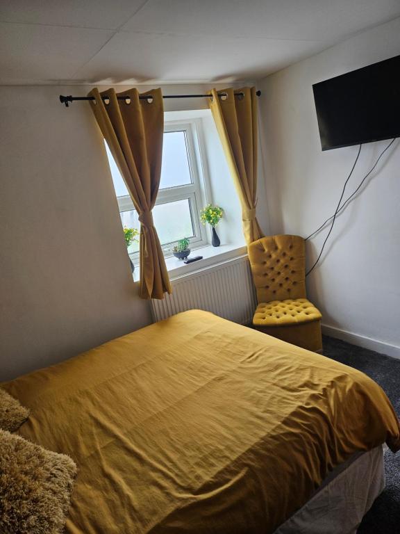 a bedroom with a yellow bed and a window at the seaview lodge in Blackpool
