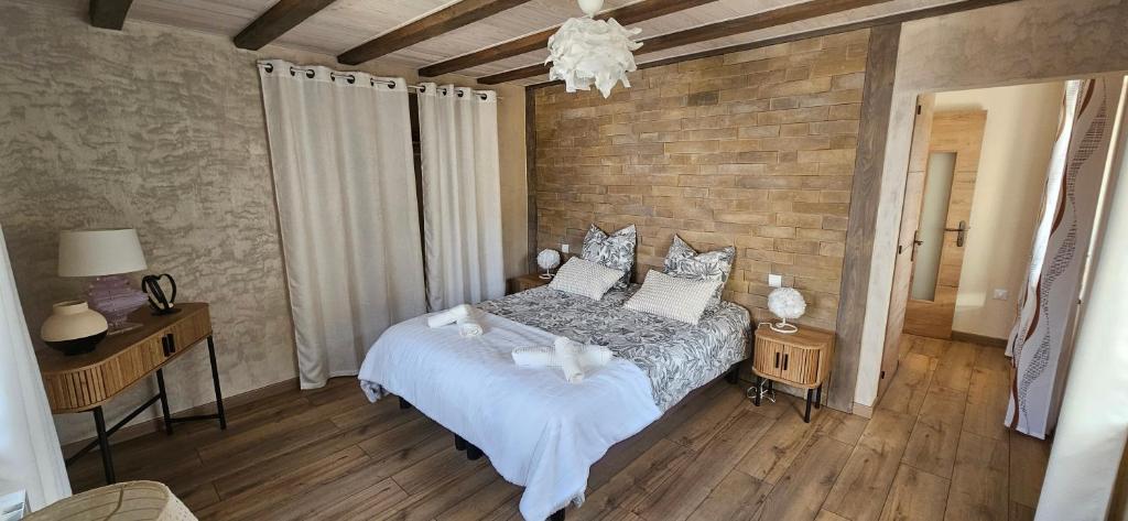 a bedroom with a bed and a brick wall at Chez Denise in Eglingen