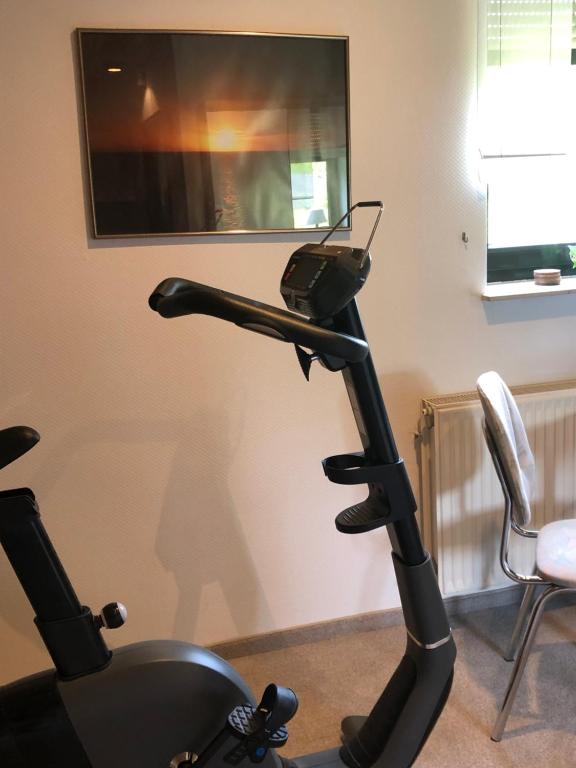 a treadmill in a room with a tv on the wall at Gemütliches Studio am Riepen in Hameln