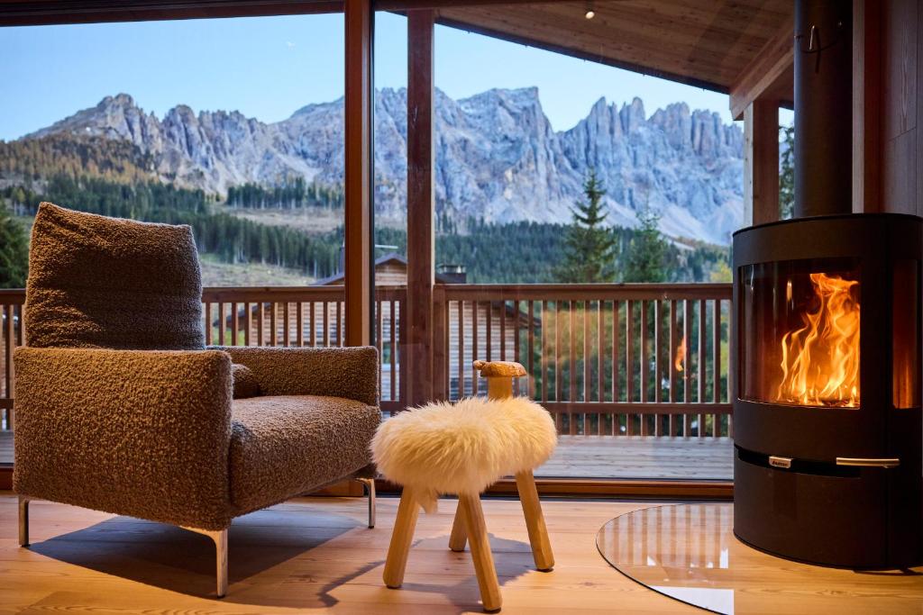 a living room with a chair and a fireplace at Eagle & Marmot, Carezza Dolomites in Carezza al Lago