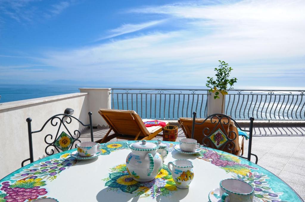 una mesa con set de té en la parte superior de un balcón en Casa La Ulivella en Praiano