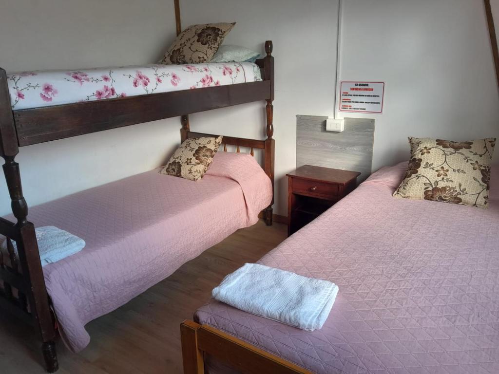 a room with two bunk beds and a bench at Alojamiento Punta Arenas in Punta Arenas