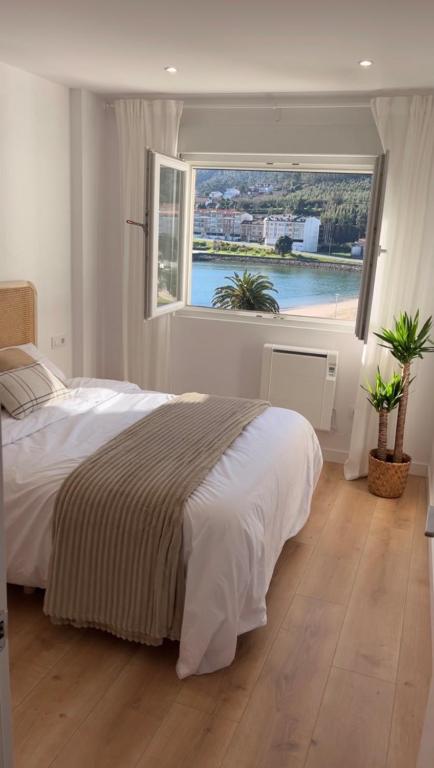 a bedroom with a large bed with a large window at RÍA LIVING - Mar 03 in Cee