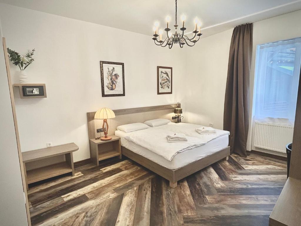 a bedroom with a bed and a chandelier at OH Apartments & Rooms in Ljubljana