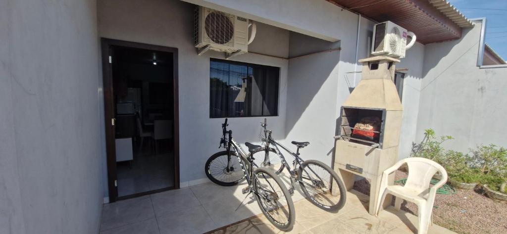 a bike parked next to a house with a fireplace at Casa 2 quartos, Pet Friendly, 06 pessoas Sinop in Sinop