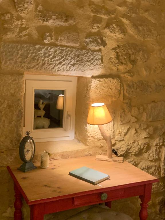 a table with a lamp and a mirror on it at La Petite Quinotte in Cadillac