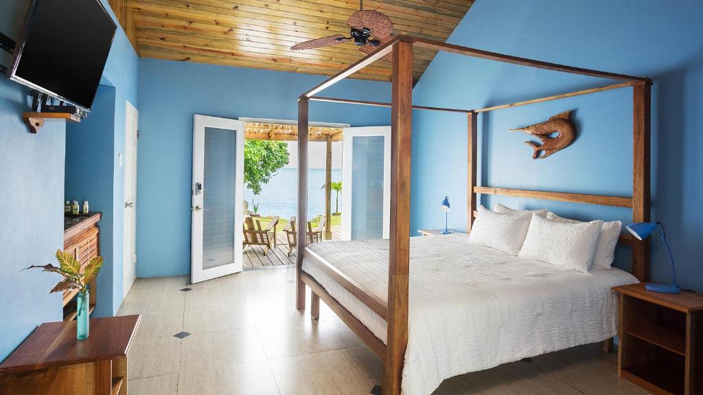 a bedroom with a canopy bed with a view of the ocean at Luna Sea Inn in Bluefields