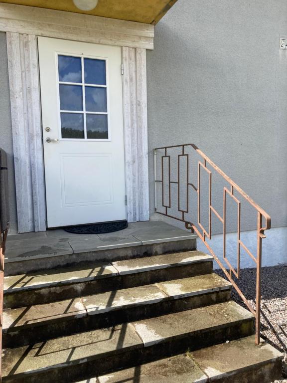 a white door on a house with stairs at Känslans in Årjäng