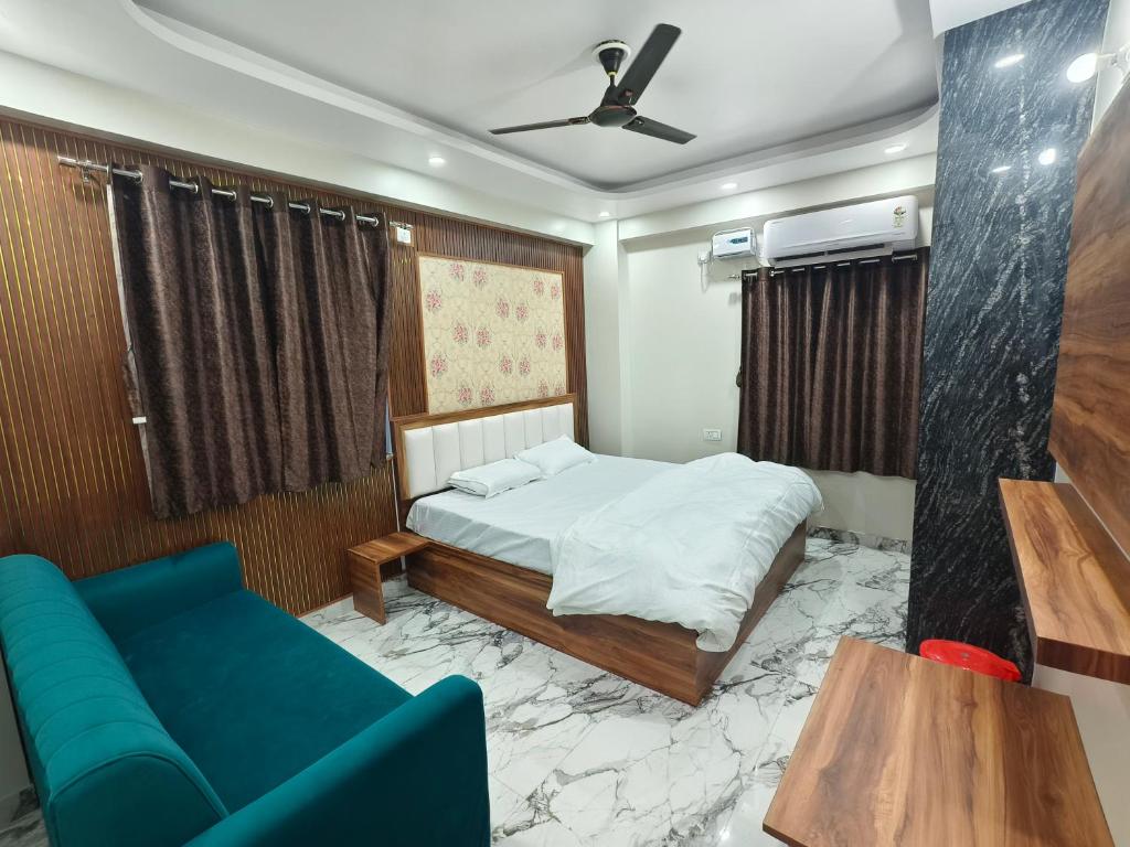 a bedroom with a bed and a blue couch at Hotel Blue Neck in Patna