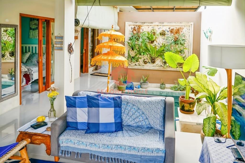 a living room with a couch and some plants at Unique 2BR Gianyar Villa Rice Field View & Pool in Blahbatu