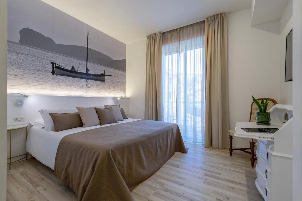 a bedroom with a bed with a boat on the wall at RelaisApartments PORTO in Alghero