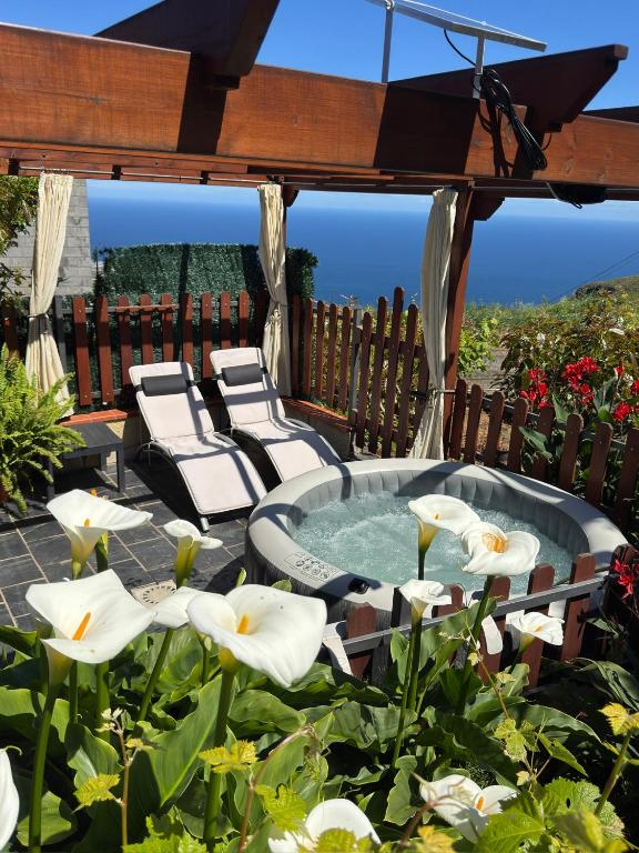 a gazebo with chairs and a hot tub with white flowers at Casa colon in Los Silos