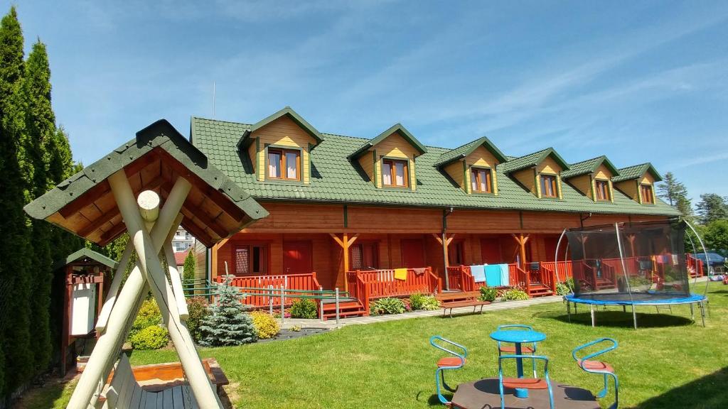 a large house with a playground in front of it at Dw Perła Sarbinowo in Sarbinowo