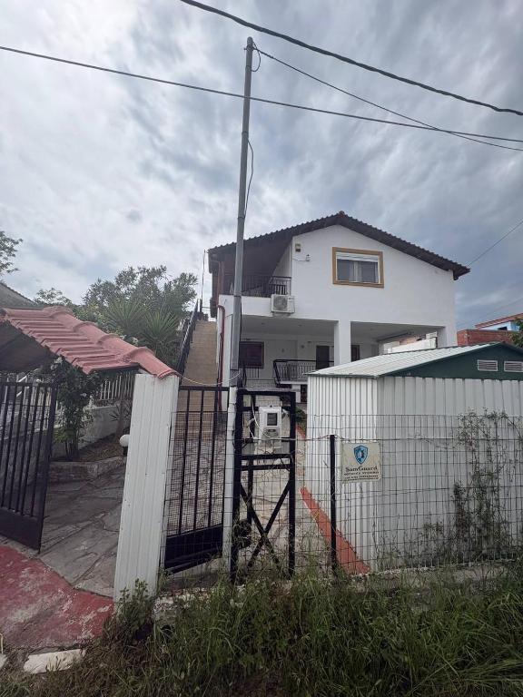 a white house with a fence in front of it at Greek Hacienda in Nea Kallikrateia