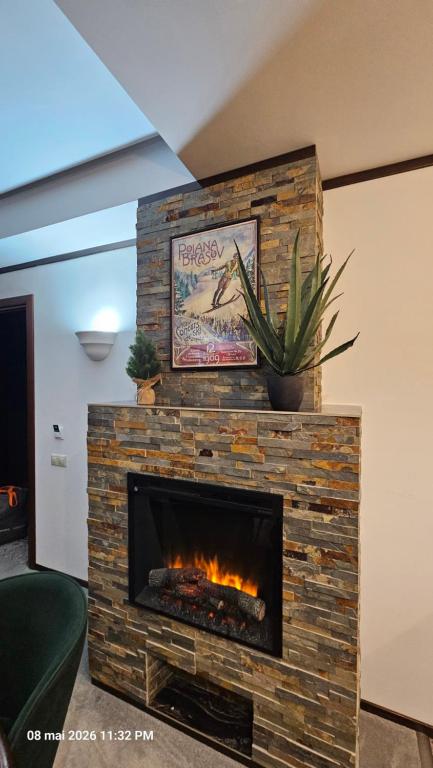 a brick fireplace in a living room with a fire place at Alpin Aparthotel Ap 508 Poiana Brasov- acces la piscină gratuit in Poiana Brasov