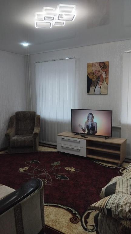 a living room with a flat screen tv and a couch at Котэдж Посуточно in Zhovti Vody